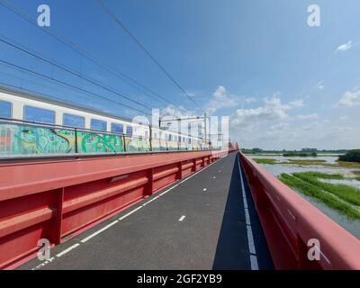 Der internationale Zug fährt über den Hanzeboog-Zug über den Fluss IJssel in Zwolle Stockfoto