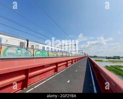 Der internationale Zug fährt über den Hanzeboog-Zug über den Fluss IJssel in Zwolle Stockfoto