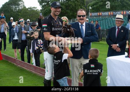 Egham, Surrey, Großbritannien. August 2021. John Collins, CEO und Gründer von Talacrest, überreicht dem Kapitän des Bardon Polo Teams, Andras Tombor, die Talacrest Trophy, nachdem er im Unterfinale des Talacrest Prince of Wales beim Championship Cup gespielt hat. Das Bardon Polo Team besiegte das UAE Polo Team. Quelle: Maureen McLean/Alamy Stockfoto