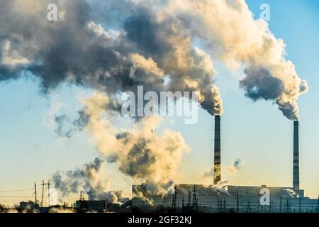 Sonnenuntergang über der Industriestadt.Fabrikschornsteine rauchen.Umweltproblem der Umwelt Und Luftverschmutzung.Klimawandel,Umwelt d Stockfoto