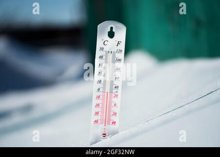 Im Winter oder Frühling liegt das Thermometer auf dem Schnee Und zeigt eine negative Temperatur bei kaltem Wetter.Meteorologische Bedingungen mit Niedrige Luft und Ambie Stockfoto