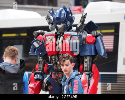 Eine Person, die als Optimus Prime gekleidet ist, posiert mit einem Touristen auf dem Times Square. Stockfoto