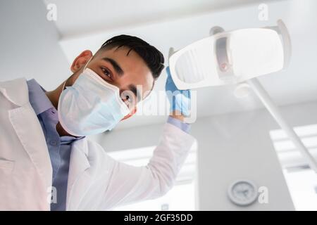 Arabischer Zahnarzt, Lampe Vor Der Patientenüberprüfung Einschalten, Niedriger Winkel Stockfoto