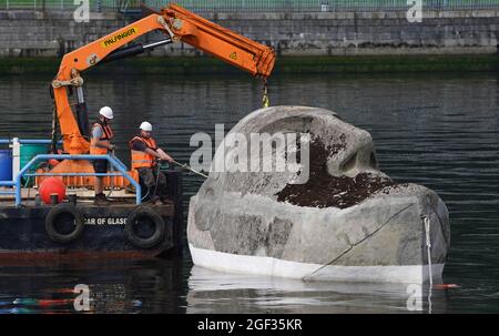 Die 27 Tonnen schwere Skulptur Floating Head aus Beton und Stahl des Künstlers Richard Groom wird etwa 33 Jahre nach ihrer Entstehung für das Glasgow Garden Festival am Fluss Clyde in der Nähe des Glasgow Science Center aufgestellt. Bilddatum: Montag, 23. August 2021. Stockfoto