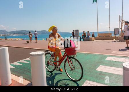 Nizza, Frankreich, Frau Bicyling auf Straßenszene, in der Nähe von Strand, Hitzewelle Urlaub, Urlaub, urbane Mobilität, öffentlicher Raum Ökologie, heißes Wetter, Frankreich Radfahren in der Stadt, Promenade des Anglais Strandspaß Nizza Stockfoto