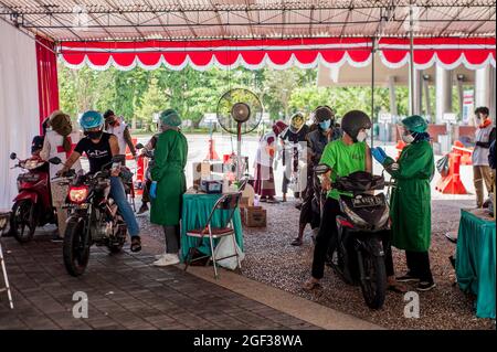 Yogyakarta, Indonesien. August 2021. Motorradfahrer warten in der Schlange, um den COVID-19-Impfstoff bei einer Durchfahrimpfung in Yogyakarta, Indonesien, am 23. August 2021 zu erhalten. Bis heute haben mindestens 32.04 Millionen Menschen in Indonesien zwei Impfungen erhalten und 57.77 Millionen haben die erste Dosis erhalten, sagte das indonesische Gesundheitsministerium am Montag. Die Regierung hat das Ziel, 208.2 Millionen Menschen zu impfen. Quelle: Supriyanto/Xinhua/Alamy Live News Stockfoto