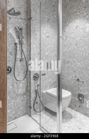 Modernes, minimalistisches Badezimmer mit Chrom-Accessoires im Badezimmer und grauen Fliesen Stockfoto