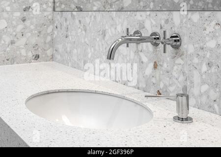 Modernes, minimalistisches Badezimmer mit Chrom-Accessoires im Badezimmer und grauen Fliesen Stockfoto