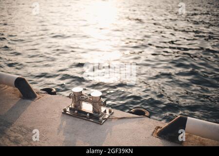 Metallbollard für Boote und Schiffe auf dem Kai über dem Meer und Sonnenuntergang Hintergrund aus nächster Nähe. Seeküsten mit Ausrüstung für das Jagen an der Küste. Reise Stockfoto