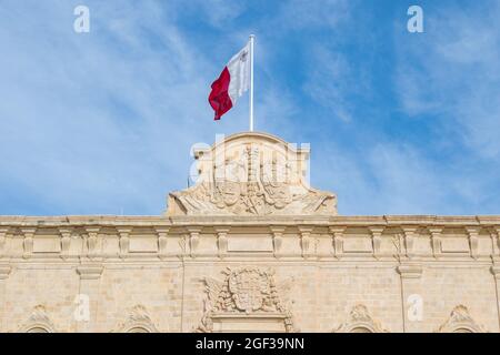 VALLETTA, MALTA - 07. Jan 2021: Eine Wappenskulptur auf der Auberge de Castille, die im Barockstil von den Johanniterrittern erbaut wurde und heute als Offi genutzt wird Stockfoto