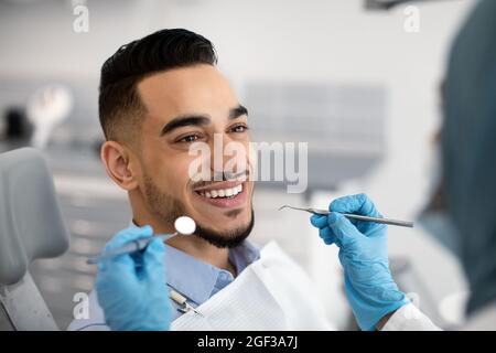 Nahaufnahme Eines Glücklichen Patienten Aus Dem Nahen Osten, Der Zahnärztliche Behandlung In Der Modernen Klinik Erhält Stockfoto