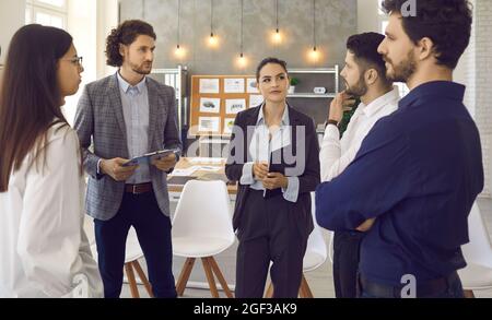 Eine Gruppe junger Kollegen im Büro diskutiert über die Entwicklung des Unternehmens Stockfoto