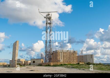 MELLIEHA, MALTA - 04. Jan 2021: Radarstation und Metallturm am Rande einer Klippe in der Landschaft von Mellieha, Malta, an einem schönen bewölkten Tag. Stockfoto