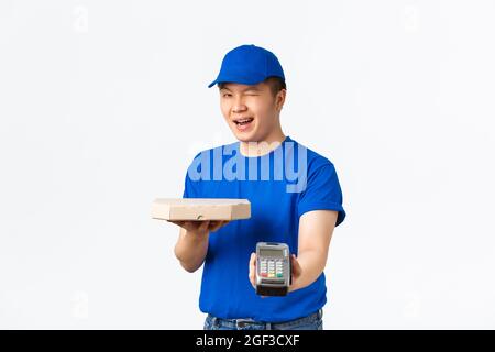 Kontaktloses Einkaufs-, Zahlungs- und Lieferkonzept. Fröhlich freundlich, lächelnd asiatischen Kurier in blauer Uniform bringen Ordnung zum Kunden nach Hause, Übergabe Pizza Stockfoto