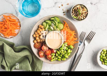 Vegane Salatschüssel mit Hummussauce. Buddha-Schüssel mit Gemüse und Bohnen Stockfoto