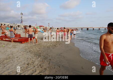 Versilia, Italien. August 2021. Am 22. August 2021 entspannen sich die Menschen am Ufer der Versilia in der Toskana, Italien. Die Toskana hat mehr als 400 km (250 Meilen) Küste. Der nördliche Teil der Insel, die Versilia genannt wird, hat einen breiten und langen Sandstrand, der kilometerweit von Marina di Carrara bis Torre del Lago Puccini reicht und glamouröse Resorts wie Forte dei Marmi, Marina di Pietrasanta und Viareggio umfasst. Hunderte von Badeanstalten bedecken die Küste, mit Apuanischen Alpen, einer sehr beeindruckenden Bergkette im Hintergrund.(Foto: Elisa Gestri/Sipa USA) Quelle: SIPA USA/Alamy Live News Stockfoto