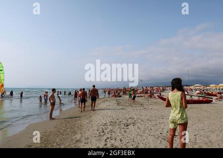 Versilia, Italien. August 2021. Menschen an der Küste der Versilia, Toskana, Italien, am 22. August 2021. Die Toskana hat mehr als 400 km (250 Meilen) Küste. Der nördliche Teil der Insel, die Versilia genannt wird, hat einen breiten und langen Sandstrand, der kilometerweit von Marina di Carrara bis Torre del Lago Puccini reicht und glamouröse Resorts wie Forte dei Marmi, Marina di Pietrasanta und Viareggio umfasst. Hunderte von Badeanstalten bedecken die Küste, mit Apuanischen Alpen, einer sehr beeindruckenden Bergkette im Hintergrund.(Foto: Elisa Gestri/Sipa USA) Quelle: SIPA USA/Alamy Live News Stockfoto