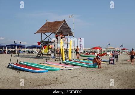 Versilia, Italien. August 2021. Eine Surfvermietung am Strand in der Versilia, Toskana, Italien, am 22. August 2021. Die Toskana hat mehr als 400 km (250 Meilen) Küste. Der nördliche Teil der Insel, die Versilia genannt wird, hat einen breiten und langen Sandstrand, der kilometerweit von Marina di Carrara bis Torre del Lago Puccini reicht und glamouröse Resorts wie Forte dei Marmi, Marina di Pietrasanta und Viareggio umfasst. Hunderte von Badeanstalten bedecken die Küste, mit Apuanischen Alpen, einer sehr beeindruckenden Bergkette im Hintergrund.(Foto: Elisa Gestri/Sipa USA) Quelle: SIPA USA/Alamy Live News Stockfoto