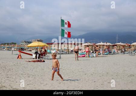 Versilia, Italien. August 2021. Menschen, die am 22. August 2021 an einem Strand in der Versilia, Toskana, Italien, gesehen wurden. Die Toskana hat mehr als 400 km (250 Meilen) Küste. Der nördliche Teil der Insel, die Versilia genannt wird, hat einen breiten und langen Sandstrand, der kilometerweit von Marina di Carrara bis Torre del Lago Puccini reicht und glamouröse Resorts wie Forte dei Marmi, Marina di Pietrasanta und Viareggio umfasst. Hunderte von Badeanstalten bedecken die Küste, mit Apuanischen Alpen, einer sehr beeindruckenden Bergkette im Hintergrund.(Foto: Elisa Gestri/Sipa USA) Quelle: SIPA USA/Alamy Live News Stockfoto