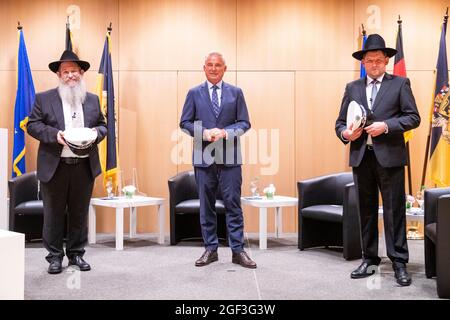 23. August 2021, Baden-Württemberg, Stuttgart: Shneur Trebnik (l.), Thomas Strobl (CDU) (M), Innenminister Baden-Württembergs, und Moshe Flomenmann stehen nach der Amtseinführung der beiden Polizeirabbiner zusammen. Foto: Tom Weller/dpa Stockfoto