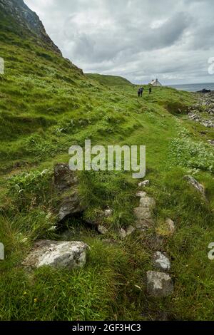 Das Haus oder das Häuschen auf Eilean an Taighe auf den Shiant Isles mit den Ruinen einer älteren Wohnung im Vordergrund. Stockfoto