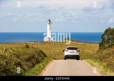 Lastres, Spanien. Der Leuchtturm von Luces in der Nähe der Küstenstadt Lastres, mit einem Auto im Vordergrund Stockfoto