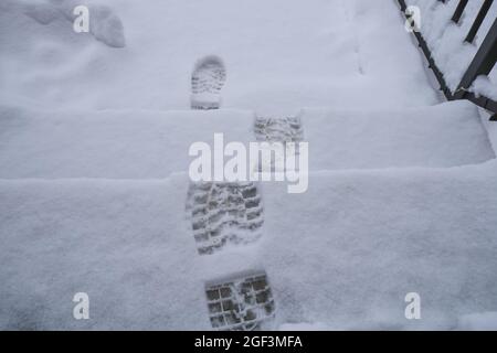 Schritte im Schnee auf der Treppe Nahaufnahme von oben. Wintersaison. Natürlicher Hintergrund Stockfoto