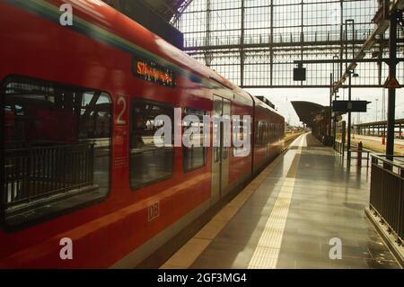 FRANKFURT, DEUTSCHLAND - 20. Aug 2021: Eine S-Bahn am Frankfurter Hauptbahnhof am Bahnsteig ist abfahrbereit. Sonnige Hintergrundbeleuchtung mit Reflexionen. Stockfoto