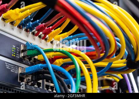 Kabel auf einem Computerserver eines Unternehmens, verschiedene Netzwerke konvergieren zentral auf dem Server, Stockfoto