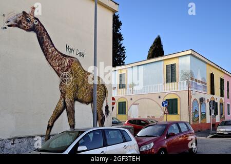 Blick auf ein Graffiti-Wandbild auf der Straße, das eine Giraffe auf einer Hauswand im Trullo-Viertel zeigt. Rom, Italien, Europa. Blauer Himmel, Kopierbereich. Stockfoto