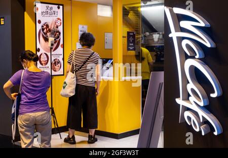 Kunden werden beim Kauf von Eis in der amerikanischen multinationalen Fast-Food-Hamburger-Restaurantkette McDonald's und McCafe Logos in Hongkong gesehen. Stockfoto