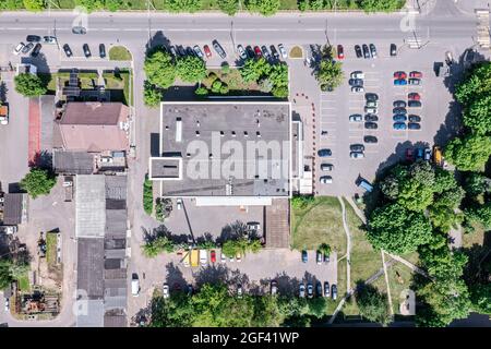 Parkplatz in der Nähe der Stadt Supermarkt mit geparkten Autos. Luftaufnahme von oben im Sommer morgens Stockfoto