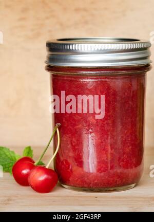 Glas Marmelade mit roten Kirschen Stockfoto