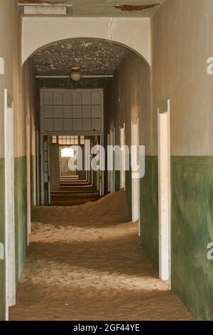 Korridor eines verlassenen, mit Sand gefüllten Krankenhausgebäudes in Kolmanskop, Namibia. Stockfoto