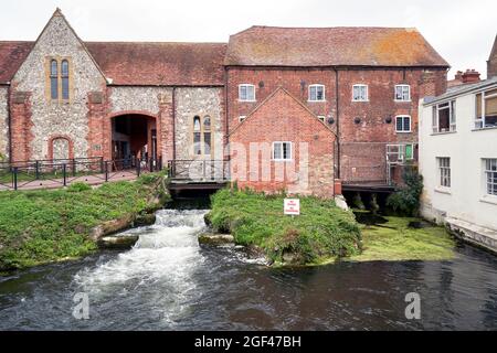 Altes Mühlengebäude in Salisbury, Großbritannien, aus rotem Backstein und einem älteren Abschnitt aus Feuerstein mit dem Fluss Avon, der darunter fließt Stockfoto