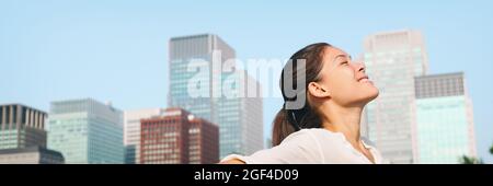 Glückliche gesunde Frau unter tiefen Atem in der Stadt saubere Luft für Verschmutzung Konzept Panorama Lansdcape Header Banner. Asiatische Dame in Asien Gesicht Porträt Stockfoto