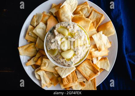 Gerösteter Knoblauch und Rosemary White Bean Dip: Dip aus Cannellini-Bohnen, Olivenöl und geröstetem Knoblauch, serviert mit Pita-Chips Stockfoto