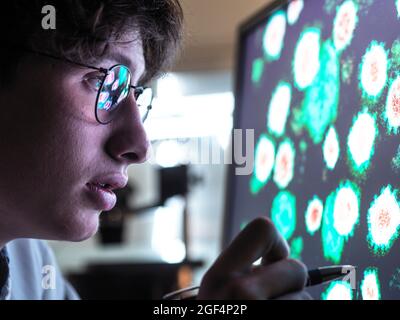 Männlicher Wissenschaftler, der im Labor an biologischen Zellen auf dem Computerbildschirm forscht Stockfoto