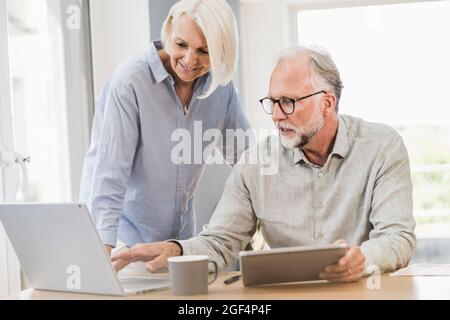 Professionelle und weibliche Mitarbeiter, die drahtlose Technologien nutzen, während sie im Home Office arbeiten Stockfoto