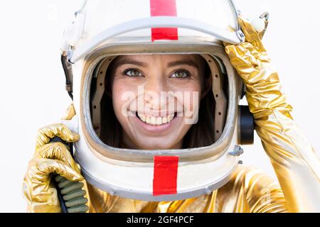 Lächelnde junge Frau mit braunen Augen und Weltraumhelm Stockfoto