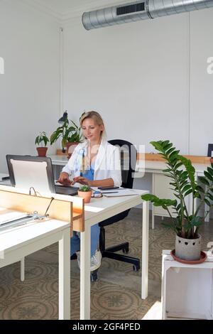 Eine Geschäftsfrau mittleren Erwachsenen, die im Büro an einem Laptop arbeitet Stockfoto