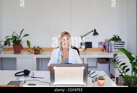 Eine weibliche Kundendienstvertreterin sitzt an der Rezeption im Büro Stockfoto