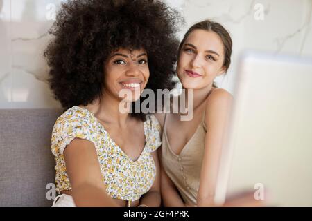 Junge multiethnische Freundinnen, die zu Hause Selfie machen Stockfoto