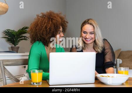 Lächelnde junge weibliche Berufstätige, die im Home Office zusammenarbeiten Stockfoto