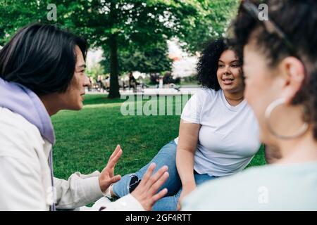 Junge Freundinnen und Freundinnen im öffentlichen Park Stockfoto