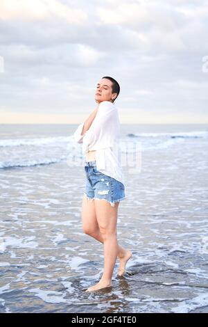 Junge Frau mit geschlossenen Augen am Strand Stockfoto