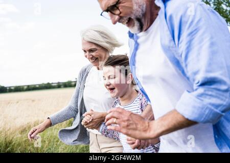 Fröhliche Enkelin und Großeltern verbringen gemeinsam Freizeit Stockfoto