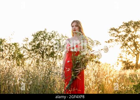 Schöne Frau mit Wildblumen Blumenstrauß Tag träumen im Feld Stockfoto