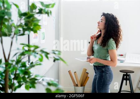 Junge Geschäftsfrau analysiert Diagramme auf dem Whiteboard im Büro Stockfoto