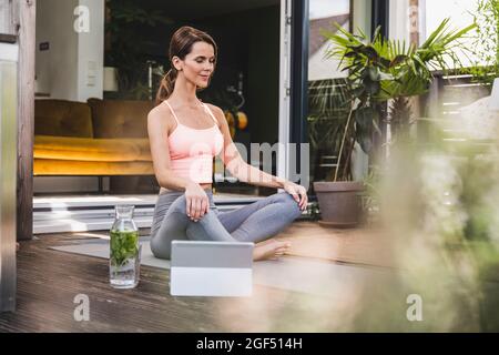 Praktizierende frau yoga auf der Terrasse Stockfoto